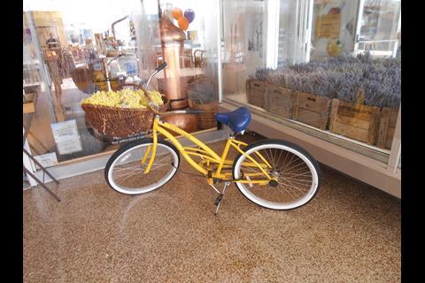 L'Occitane's Lincoln Road shop captures the feeling of Provence thanks to a window filled with lavender in aged wooden crates and a bright yellow bicycle positioned in the arcade-style entrance.